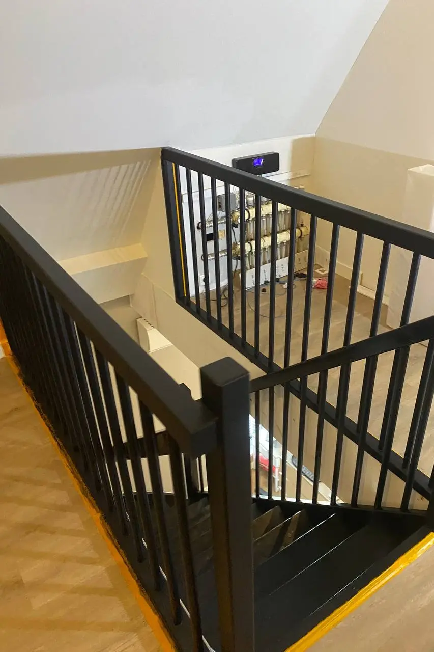 Professioneel geschilderde houten trap en leuning in een donkere kleur voor een moderne uitstraling in Den Haag en Rotterdam