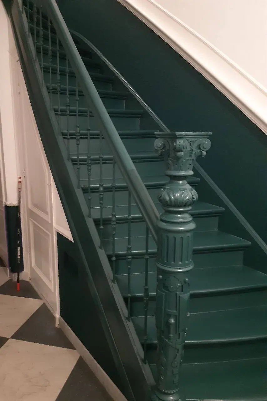 Professioneel geschilderde houten trap met smaragdgroene leuning in een luxe interieur in Den Haag en Rotterdam