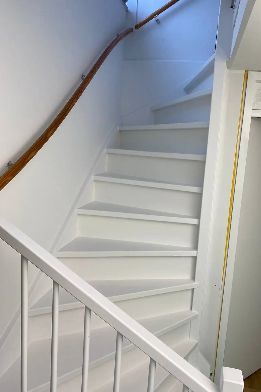 Professioneel geschilderde witte houten trap en leuning voor een moderne uitstraling in Den Haag en Rotterdam
